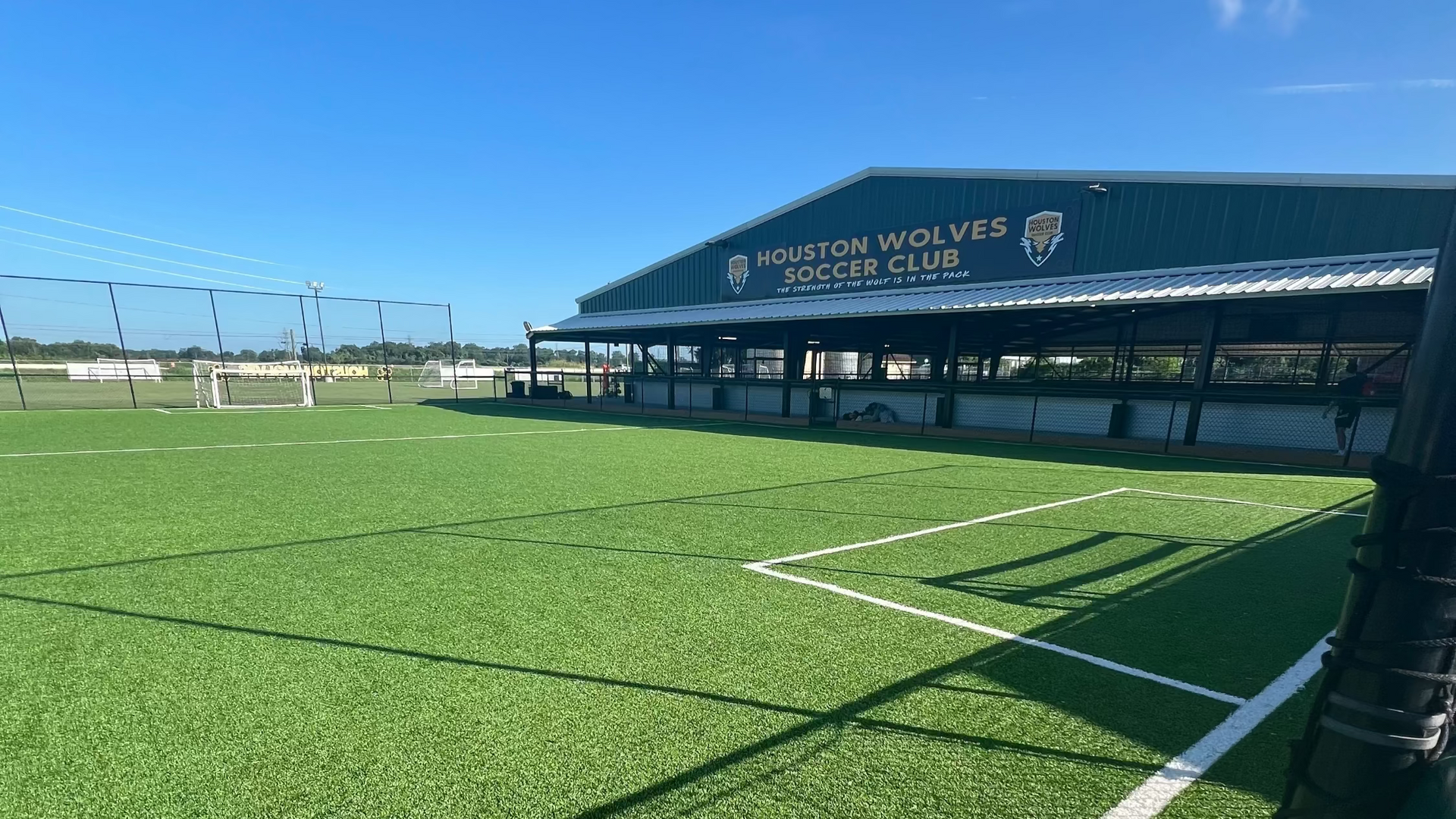 Soccer field with 'Houston Wolves Soccer Club' building in the background